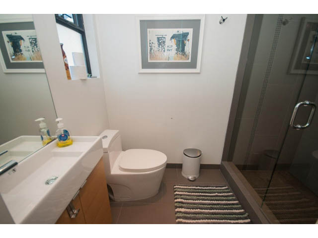 Bright bathroom with modern sink, toilet, and framed artwork. - 15 - 2151 Banbury Rd, North Vancouver