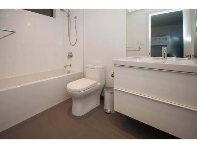 Bright bathroom with modern white fixtures and a large mirror. - 15 - 2151 Banbury Rd, North Vancouver