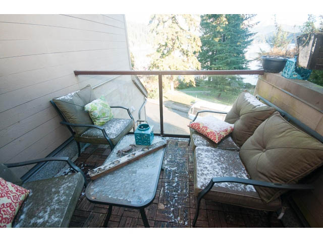 Furnished balcony with snow-covered furniture and a view of trees and mountains. - 15 - 2151 Banbury Rd, North Vancouver