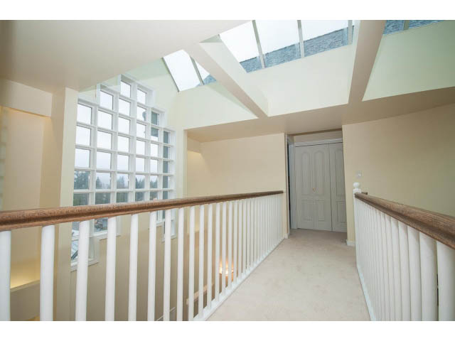 Staircase leading to second floor with skylights and white railings. - 4220 Starlight Way, North Vancouver