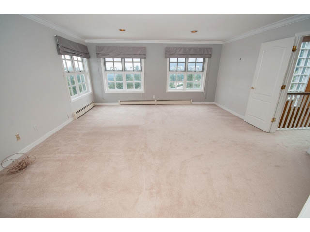 Bright living room with large windows and carpeted floors. - 4220 Starlight Way, North Vancouver