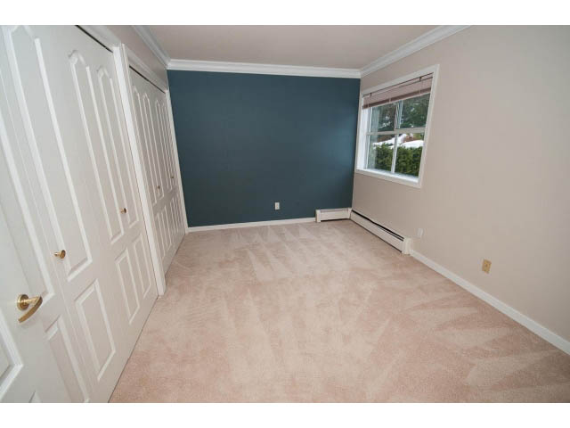 Bright bedroom with carpeted floor and dark accent wall. - 4220 Starlight Way, North Vancouver
