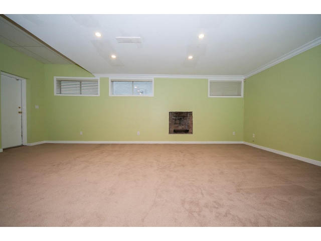 Bright living room with light green walls, beige carpet, and recessed lighting. - 4220 Starlight Way, North Vancouver