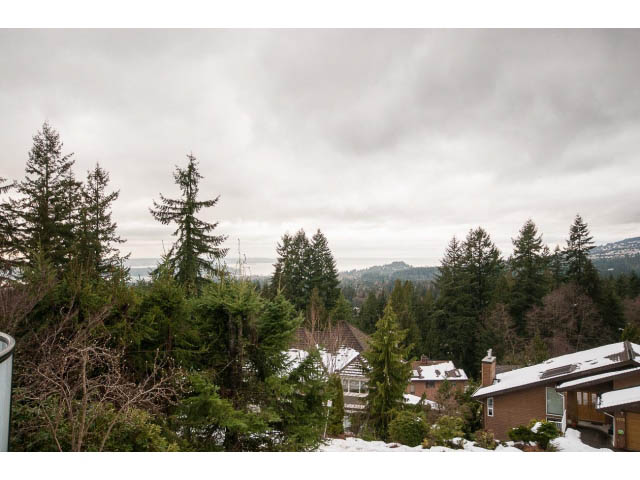 Bright living room with a stunning city view and evergreen trees. - 4220 Starlight Way, North Vancouver