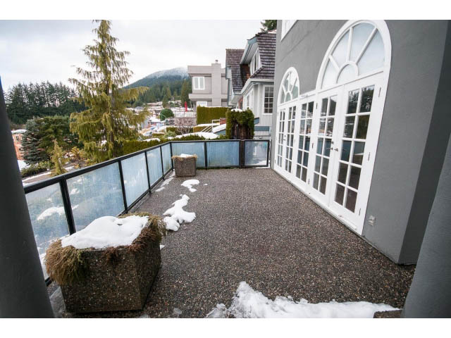 Furnished balcony with glass railing, city view, and snow patches. - 4220 Starlight Way, North Vancouver