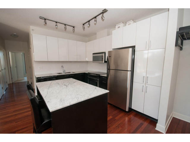 Bright kitchen with white cabinets, marble countertops, and stainless steel appliances. - 401 - 2828 Yew St, Vancouver West Side