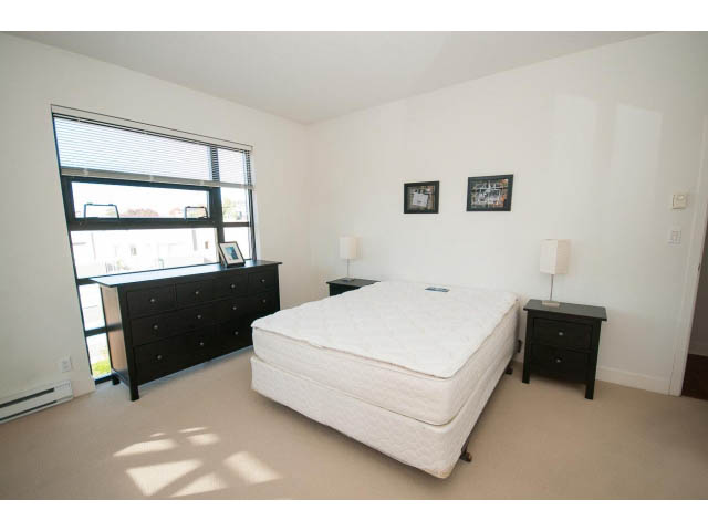 Spacious bedroom with two queen beds, white walls, and large windows offering a city view. - 401 - 2828 Yew St, Vancouver West Side