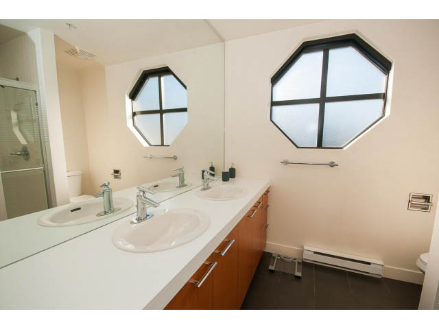 Bathroom with octagonal window and dual sinks, modern design. - 401 - 2828 Yew St, Vancouver West Side