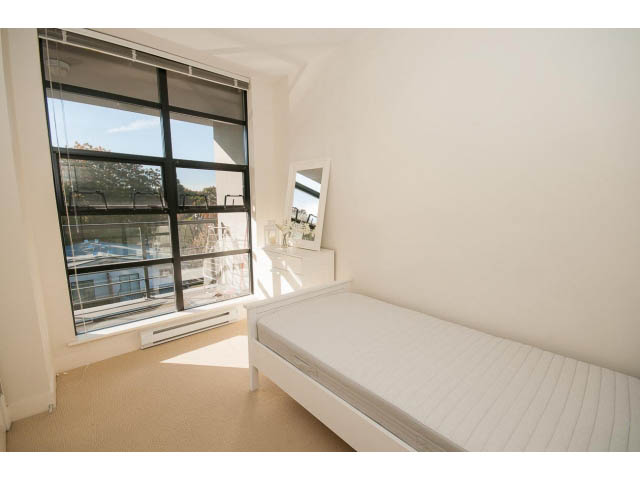 Bright bedroom with large window and city view, modern furniture. - 401 - 2828 Yew St, Vancouver West Side
