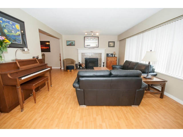 Furnished living room with hardwood floors, a piano, and a fireplace. - 2346 Riverbank Place, North Vancouver