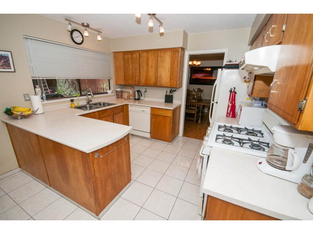 Bright kitchen with wooden cabinets, white countertops, and a city view. - 2346 Riverbank Place, North Vancouver