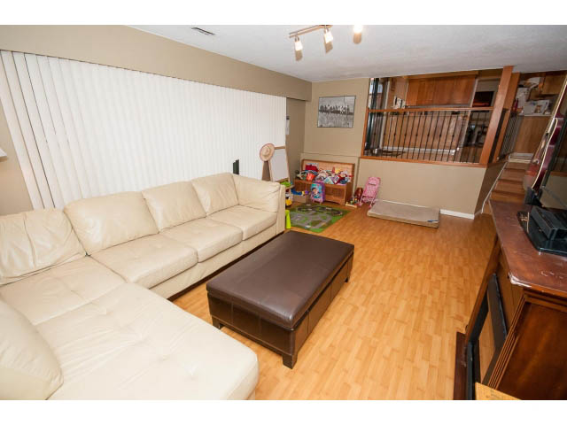 Furnished living room with hardwood floors and a large sectional sofa. - 2346 Riverbank Place, North Vancouver
