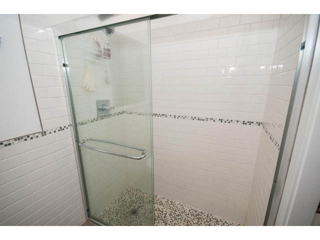 Bright bathroom with white subway tile and glass shower doors. - 2346 Riverbank Place, North Vancouver