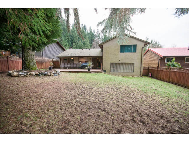 Spacious backyard with grassy lawn and wooden fence. - 2346 Riverbank Place, North Vancouver