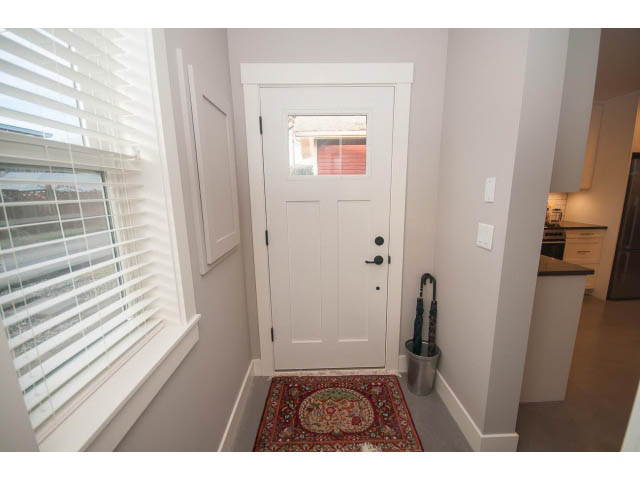 Bright entryway with white door, small rug, and window with blinds. - 2 - 217 East 19th, North Vancouver