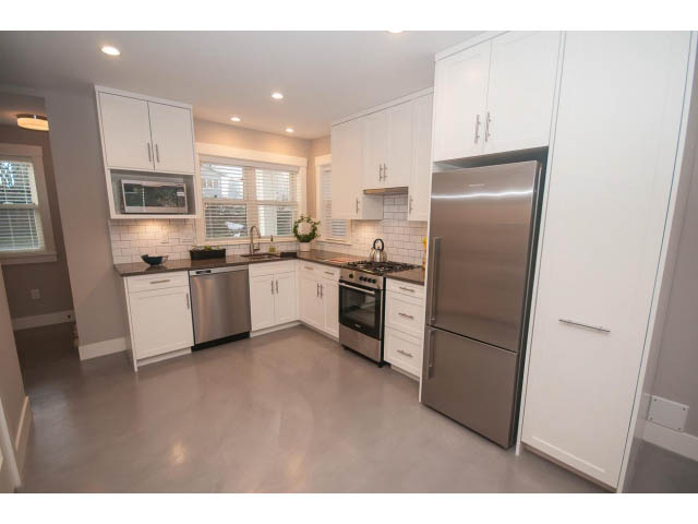 Bright kitchen with white cabinets, stainless steel appliances, and a modern design. - 2 - 217 East 19th, North Vancouver