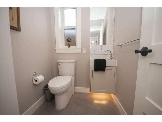 Small bathroom with white fixtures and a window. - 2 - 217 East 19th, North Vancouver