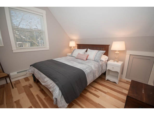 Furnished 2-bedroom house with hardwood floors and a cozy bed setup. - 2 - 217 East 19th, North Vancouver