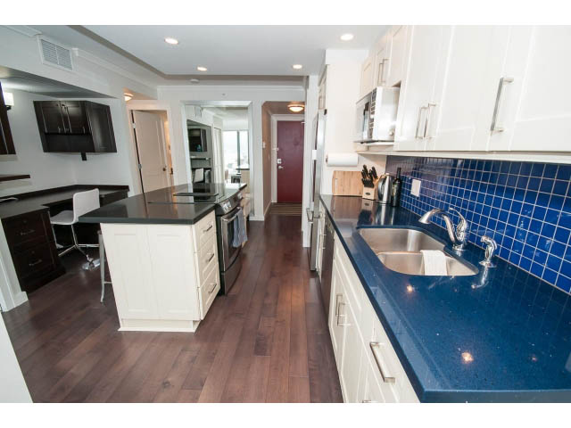 Bright kitchen with white cabinets, dark countertops, and blue backsplash. - 2407 - 1723 Alberni, Vancouver Downtown