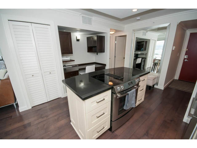 Bright kitchen with dark countertops and hardwood floors, showcasing a city view. - 2407 - 1723 Alberni, Vancouver Downtown
