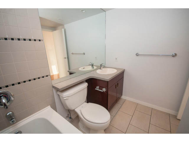 Bright bathroom with white fixtures, tiled walls, and a large mirror. - 2005 - 1067 Marinaside Crescen, Vancouver Downtown