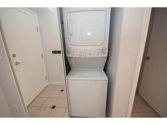 Laundry room with stacked washer and dryer, white walls, and tiled floor. - 2005 - 1067 Marinaside Crescen, Vancouver Downtown