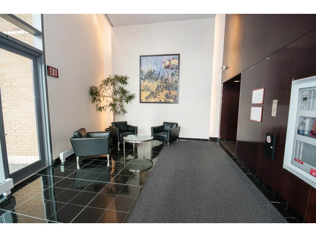 Furnished living room with modern decor, large windows, and a cozy seating area. - 2005 - 1067 Marinaside Crescen, Vancouver Downtown