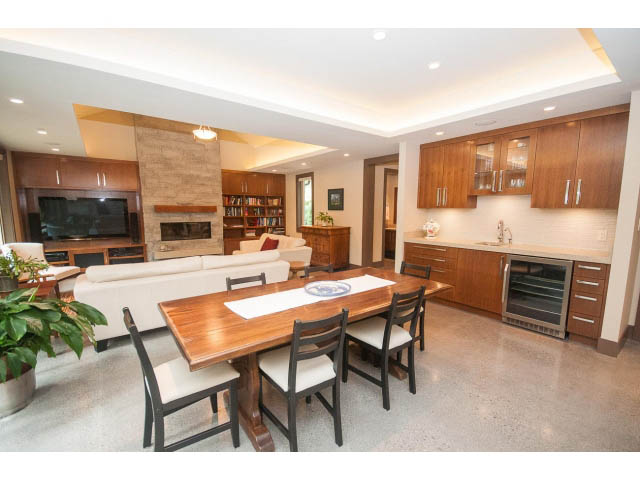 Open-concept living and dining area with modern furnishings, hardwood floors, and a kitchen island. - 5070 Marine Drive, West Vancouver