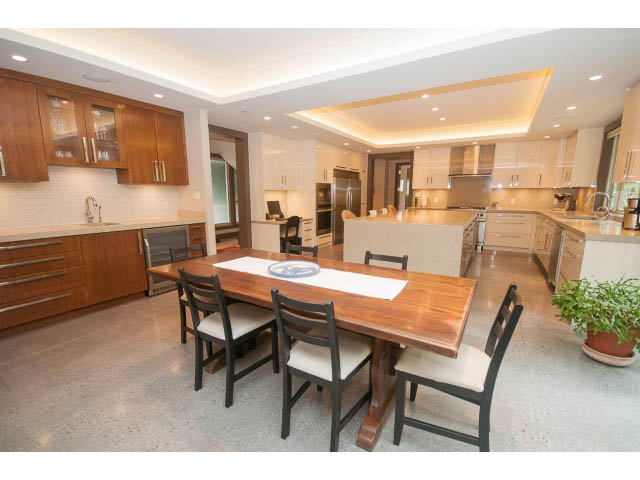 Bright kitchen with modern cabinets, granite countertops, and hardwood floors. - 5070 Marine Drive, West Vancouver