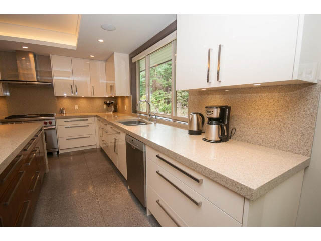 Bright kitchen with granite countertops and modern appliances, featuring a city view. - 5070 Marine Drive, West Vancouver