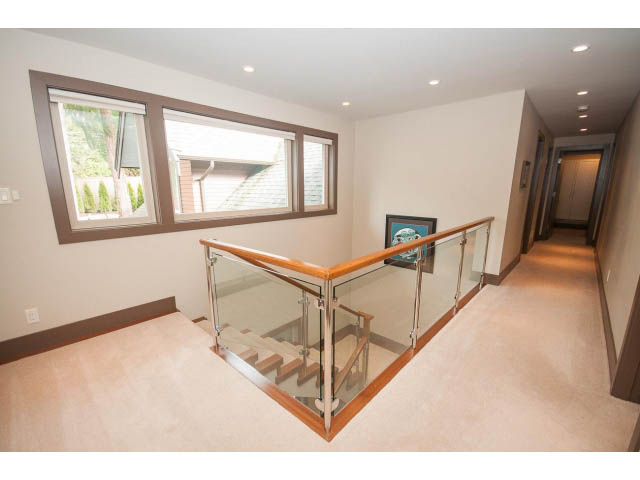 Bright living room with large windows, modern staircase, and hardwood floors. - 5070 Marine Drive, West Vancouver