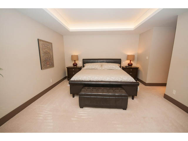 Spacious bedroom with modern furniture and soft lighting. - 5070 Marine Drive, West Vancouver