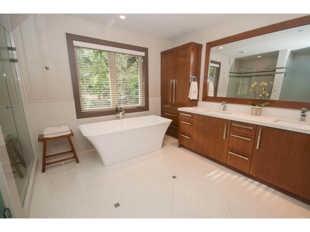 Spacious bathroom with large vanity, modern fixtures, and natural light from window. - 5070 Marine Drive, West Vancouver