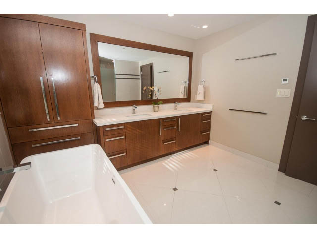 Spacious bathroom with modern vanity, large mirror, and white tile floor. - 5070 Marine Drive, West Vancouver
