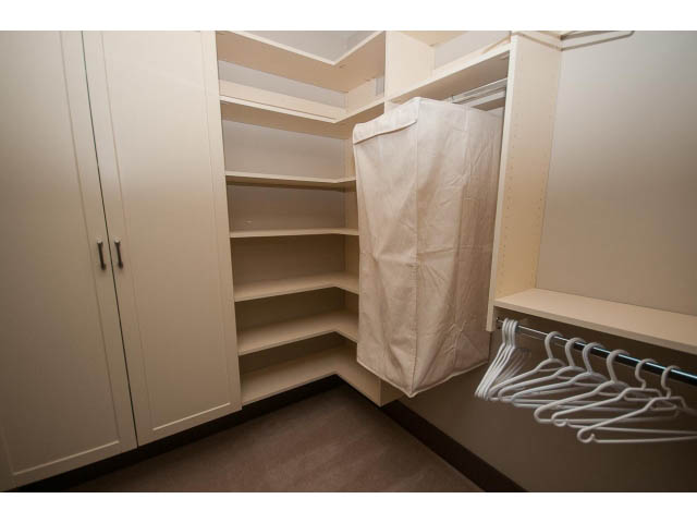 Walk-in closet with hanging rods and shelves, neatly organized. - 5070 Marine Drive, West Vancouver