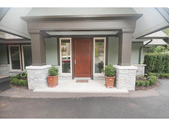 Furnished entryway with stone accents and wooden door. - 5070 Marine Drive, West Vancouver