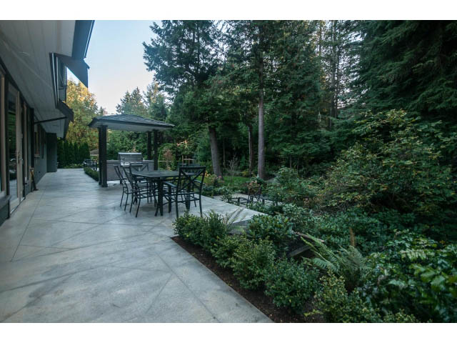 Furnished patio with outdoor seating and lush greenery. - 5070 Marine Drive, West Vancouver