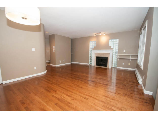 Spacious living room with hardwood floors and a fireplace, modern lighting. - 1962 West 11th Ave, Vancouver West Side