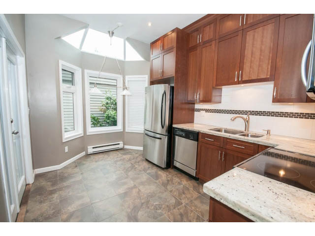 Bright kitchen with granite countertops, stainless steel appliances, and a skylight. - 1962 West 11th Ave, Vancouver West Side