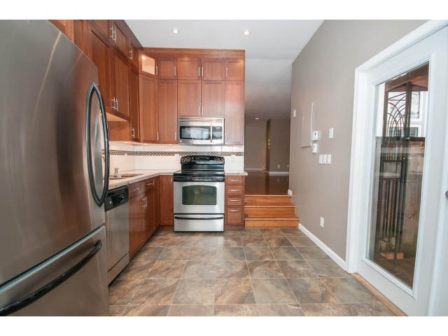 Bright kitchen with stainless steel appliances, granite countertops, and tiled flooring. - 1962 West 11th Ave, Vancouver West Side