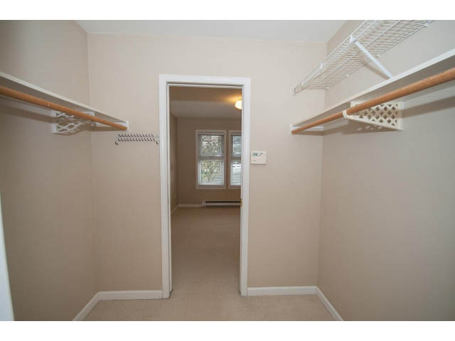 Spacious walk-in closet with shelving and hanging rods, carpeted floor. - 1962 West 11th Ave, Vancouver West Side