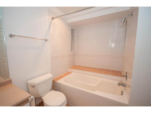 Bathroom with white fixtures, tiled steps, and a shower. - 1962 West 11th Ave, Vancouver West Side