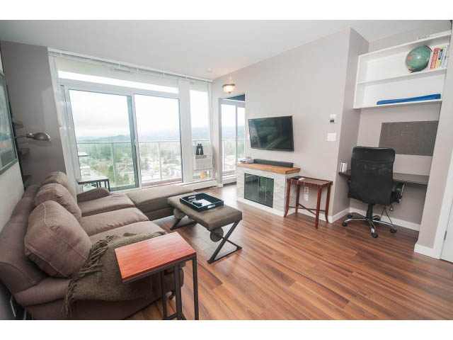 Bright living room with hardwood floors, city view, and a cozy sofa. - 1702 - 135 East 17th Street, North Vancouver