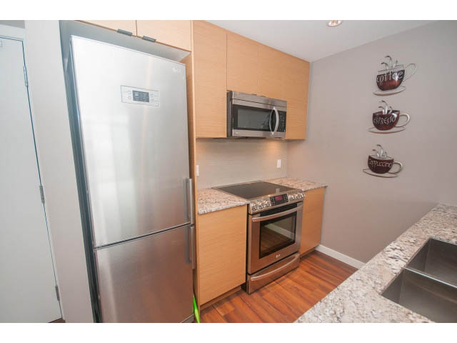 Bright kitchen with granite countertops, stainless steel appliances, and hardwood floors. - 1702 - 135 East 17th Street, North Vancouver
