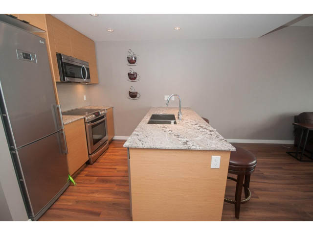 Bright kitchen with granite countertops, hardwood floors, and a modern design. - 1702 - 135 East 17th Street, North Vancouver