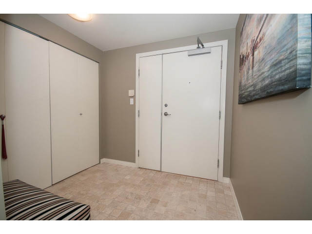 Den area with tiled floor, white closet, and abstract wall art. - 2706 -198 Aquarius Mews, Vancouver Downtown