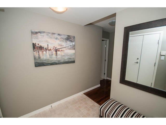 Bright den with cityscape painting, hardwood floors, and striped bench. - 2706 -198 Aquarius Mews, Vancouver Downtown