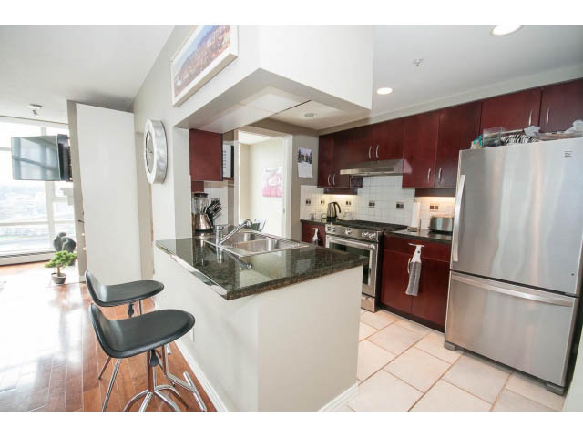 Bright kitchen with stainless steel appliances, granite countertops, hardwood floors, and a city view. - 2706 -198 Aquarius Mews, Vancouver Downtown