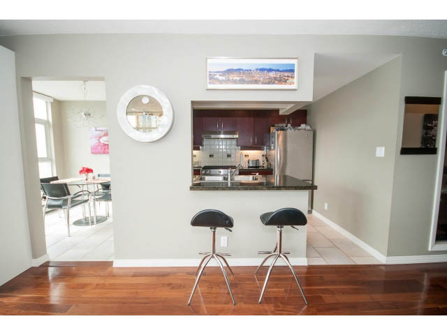 Bright kitchen with hardwood floors, modern bar stools, and a city view. - 2706 -198 Aquarius Mews, Vancouver Downtown