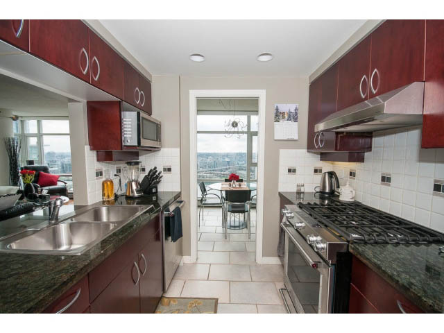 Bright kitchen with dark red cabinets, granite countertops, and a city view. - 2706 -198 Aquarius Mews, Vancouver Downtown